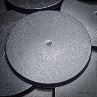 Close-up view of 70mm round bases with a black background, focusing on surface characteristics