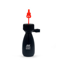 Single red AK Interactive holding pin inserted into the rotating platform of the AK9565 Handle Support showing the clip-top protruding above the textured base ready for mounting a miniature part