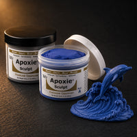 Aves Apoxie Sculpt 1lb Blue — Part A tub open showing blue putty, Part B tub behind, with a detailed sculpted dolphin leaping from an ocean wave