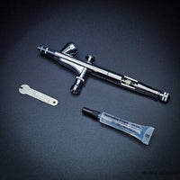 Iwata HP-B Plus kit with lube tube and wrench on black background