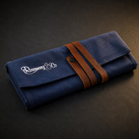 Rosemary & Co small navy fabric brush wrap shown closed with leather strap and embroidered logo