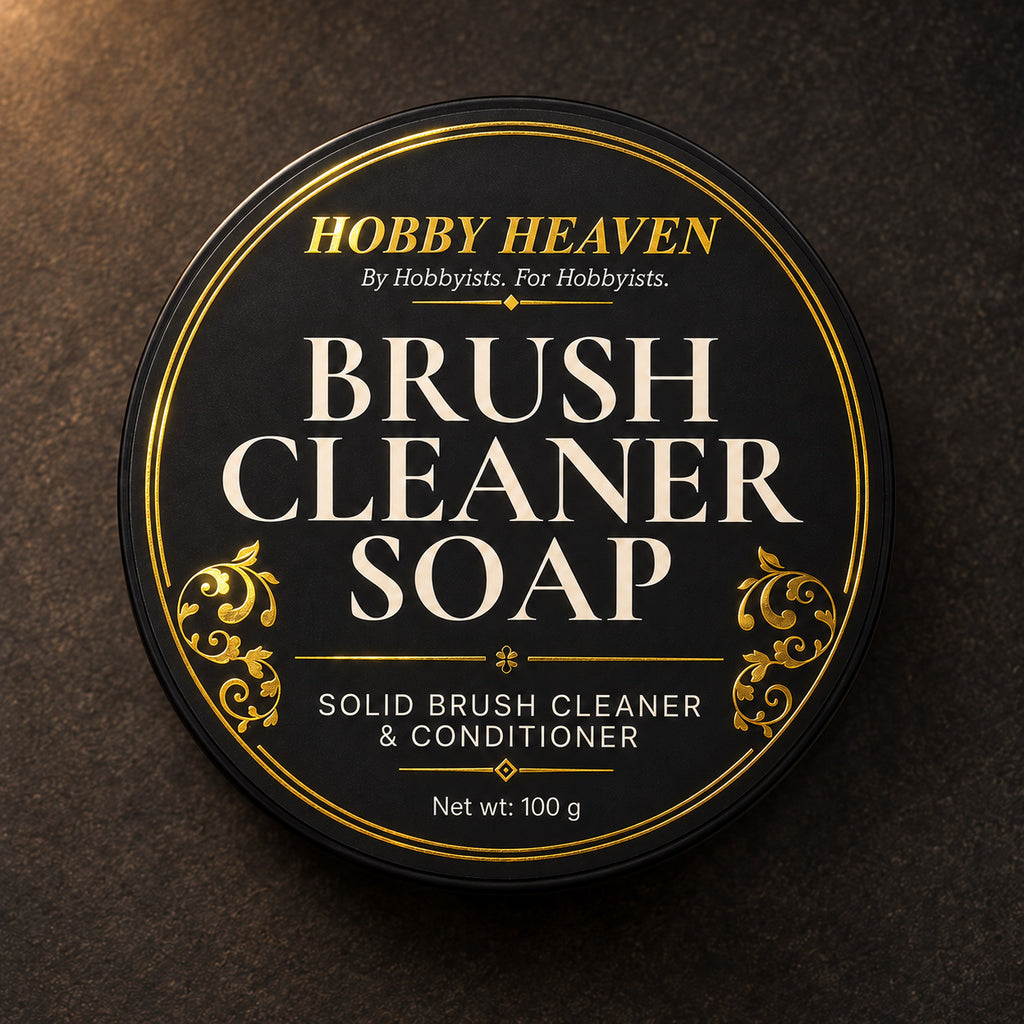 Top view of the black tin lid, gold-foil label: Brush Cleaner Soap, solid brush cleaner and conditioner, 100 g