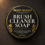 Top view of the black tin lid, gold-foil label: Brush Cleaner Soap, solid brush cleaner and conditioner, 100 g