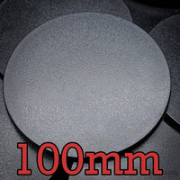 Close-up of 100mm round base on a background of other bases.
