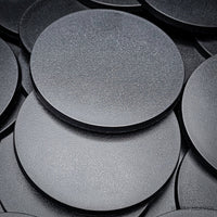 Several 100mm round bases lying in a stacked arrangement.
