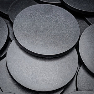 Several 100mm round bases lying in a stacked arrangement.