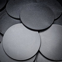 Collection of 100mm round bases arranged in a heap
