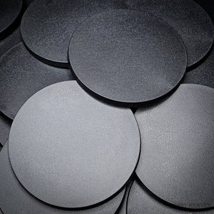 Collection of 100mm round bases arranged in a heap