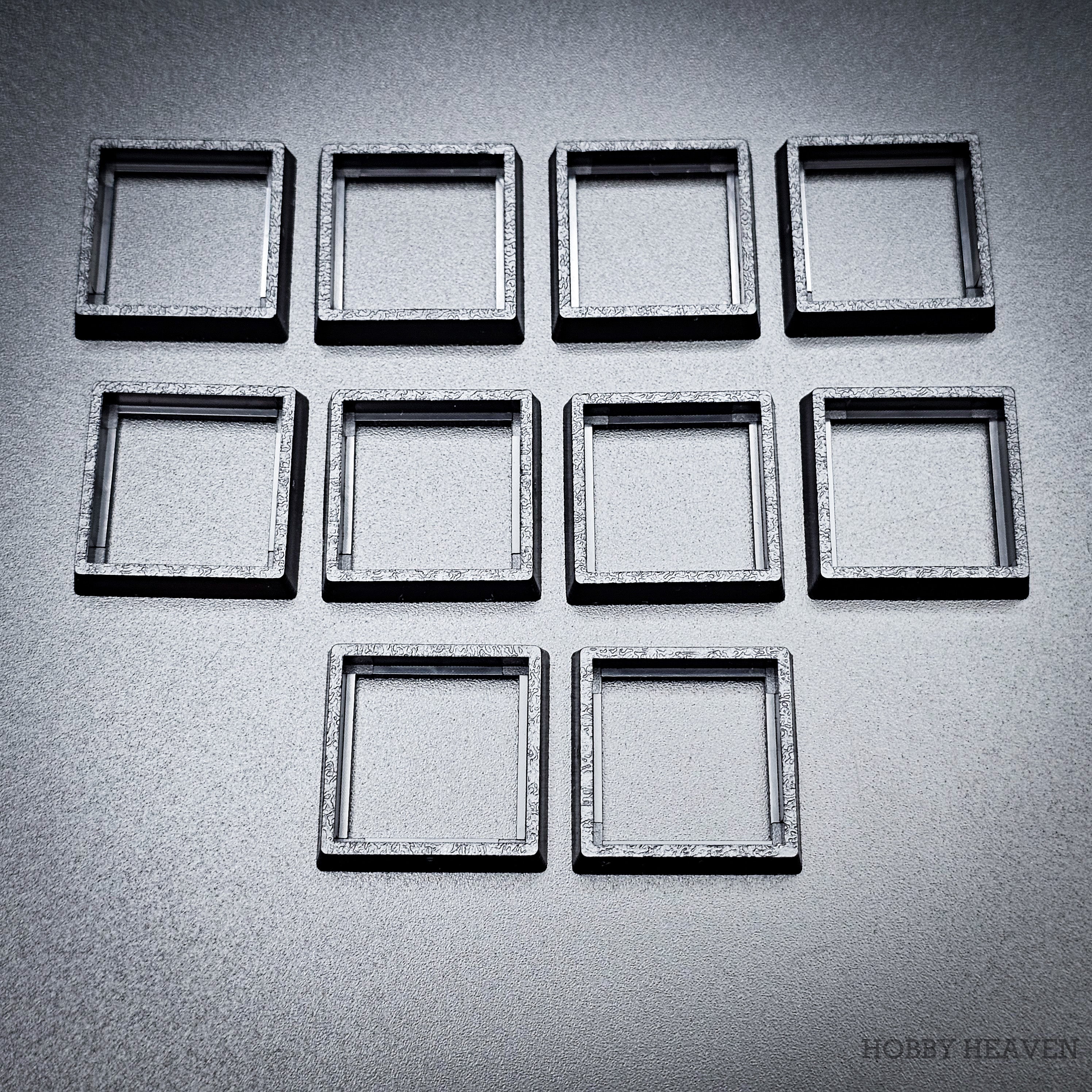 Ten base converters 20mm to 25mm square displayed in group on dark surface
