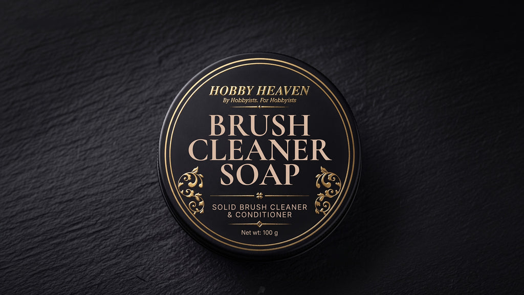 Closed black screw-top tin with the gold-foil Brush Cleaner Soap label on dark slate