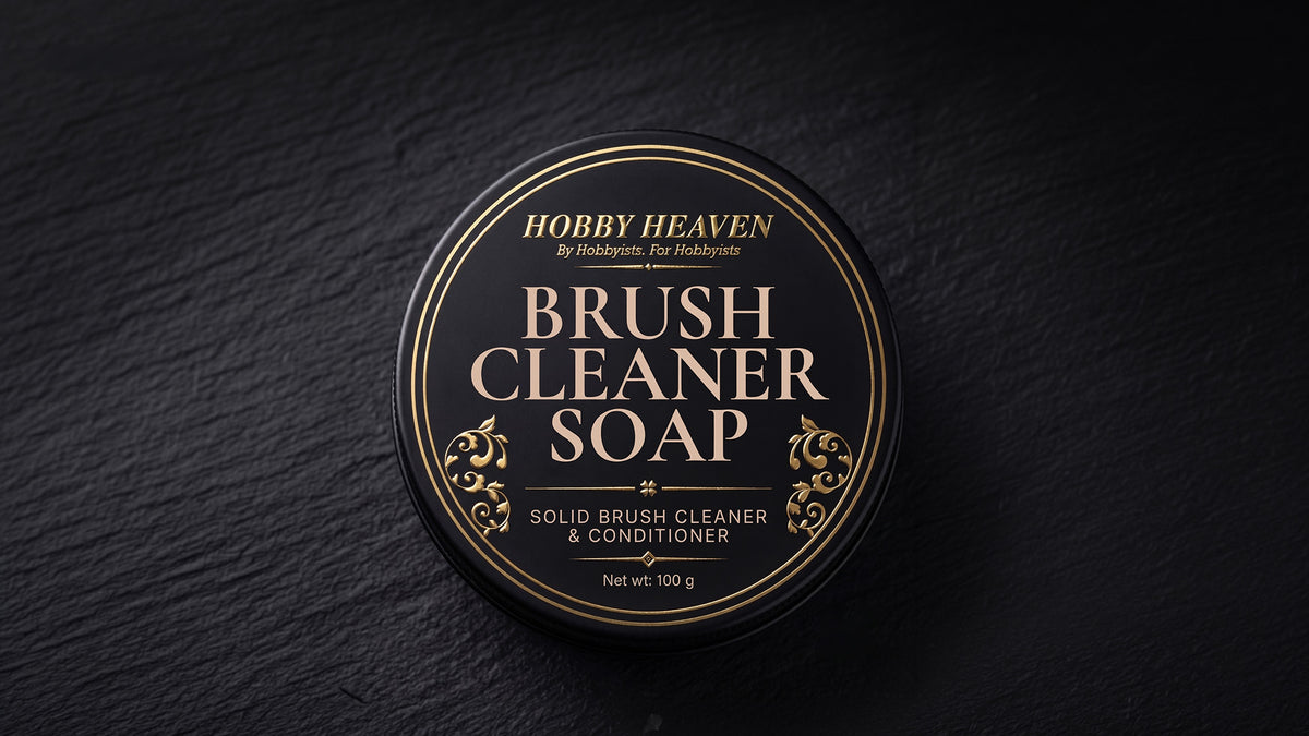 Closed black screw-top tin with the gold-foil Brush Cleaner Soap label on dark slate