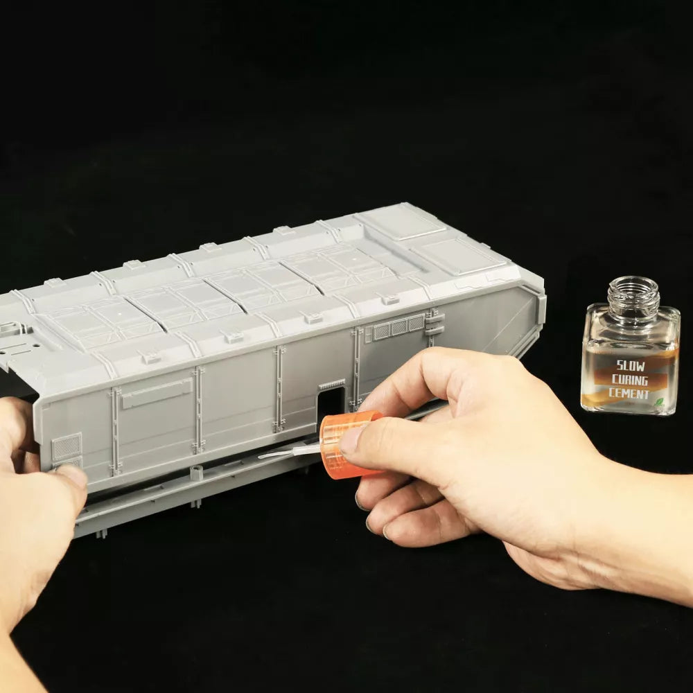 Slow Curing Cement applied with the cap applicator along a joint on a large grey plastic kit hull