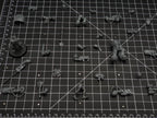 Wargaming miniature arms, weapons and torso parts laid out on a cutting mat with tiny disc magnets for weapon swaps