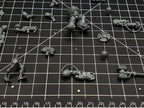 Close-up of magnetised miniature parts on a cutting mat, small disc magnets fitted for arm and weapon swaps