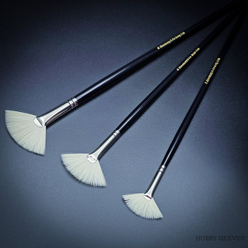 Three Rosemary & Co Ivory fan brushes laid diagonally with gold-printed black handles, sizes 2 to 6