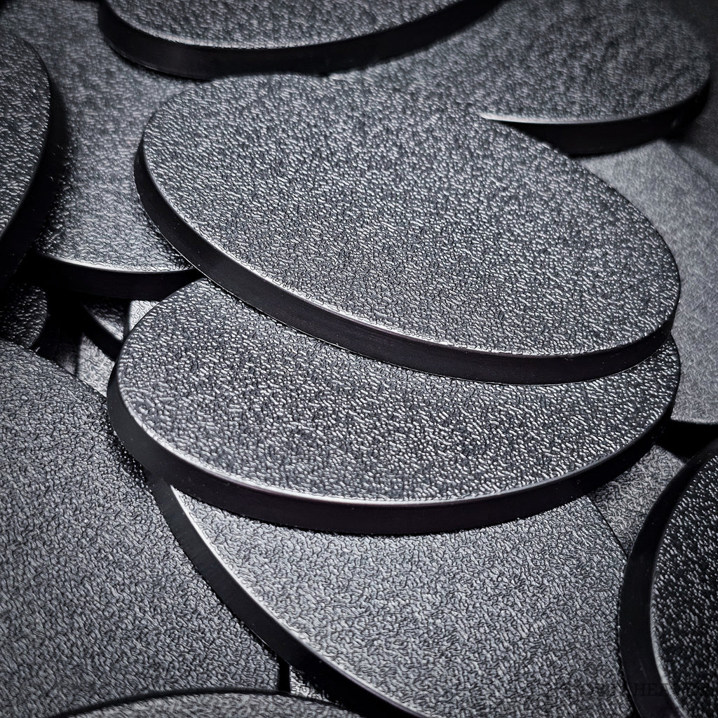 Close view of stacked 60x35mm oval plain bases, showing the textured top and the flat moulded rim