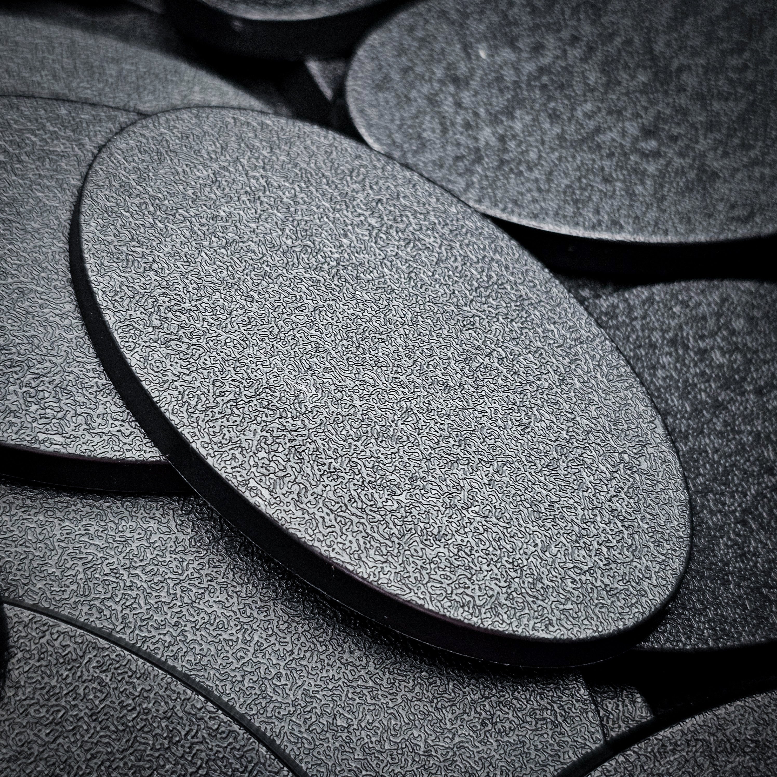 Macro view of a 60x35mm oval plain base, the fine stipple texture of the top face filling the frame