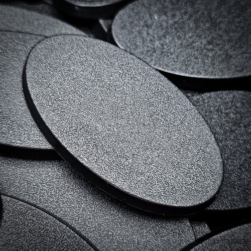Macro view of a 60x35mm oval plain base, the fine stipple texture of the top face filling the frame