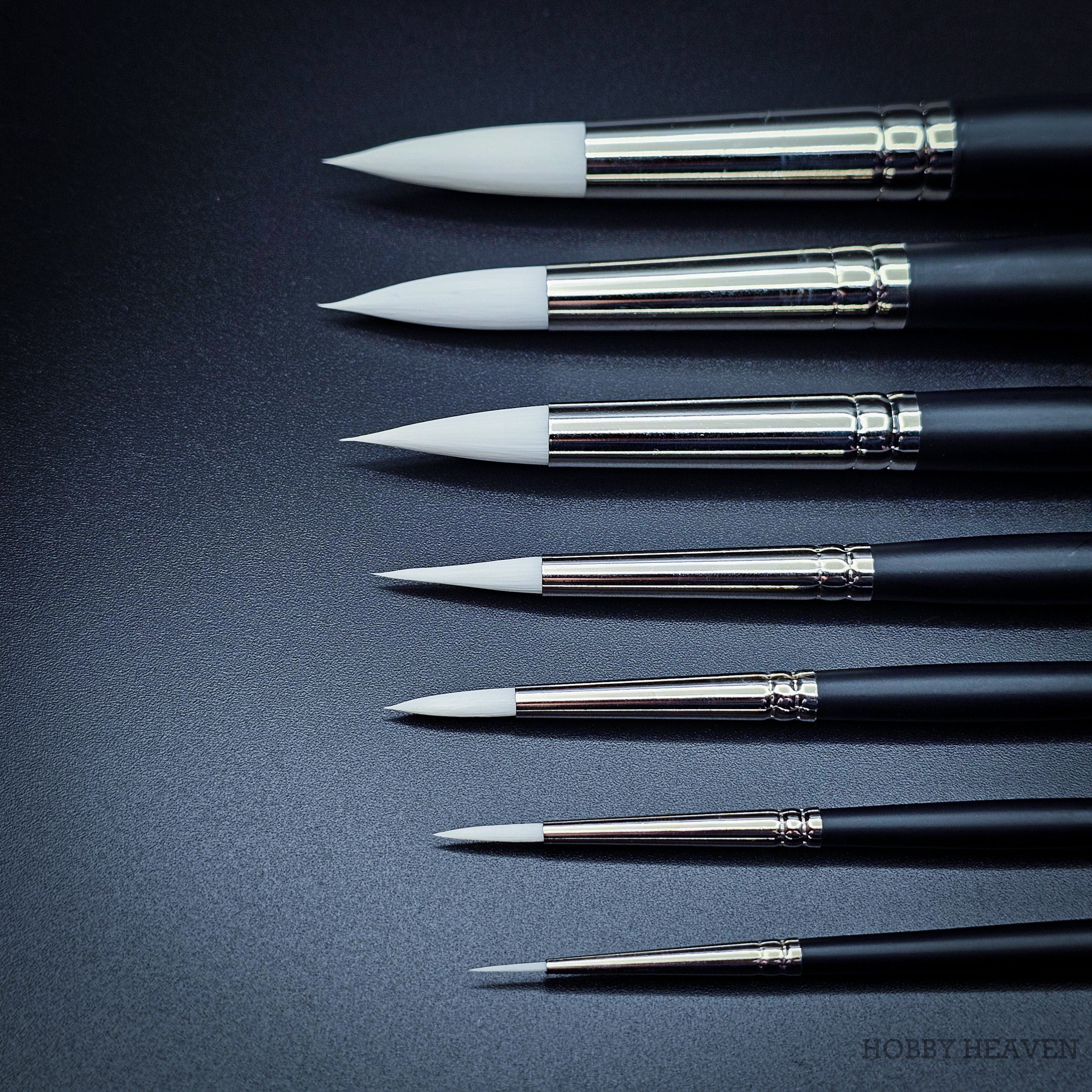 Close-up of nine Snowdrop brush heads in sizes 0 to 16 showing the tapered white taklon points and progressive size increase