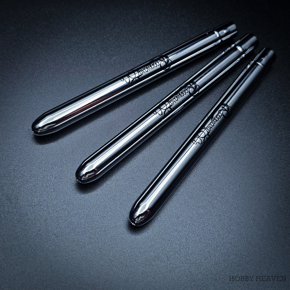 Three Pocket brushes closed with protective caps, showing polished chrome handles with Rosemary & Co engraving