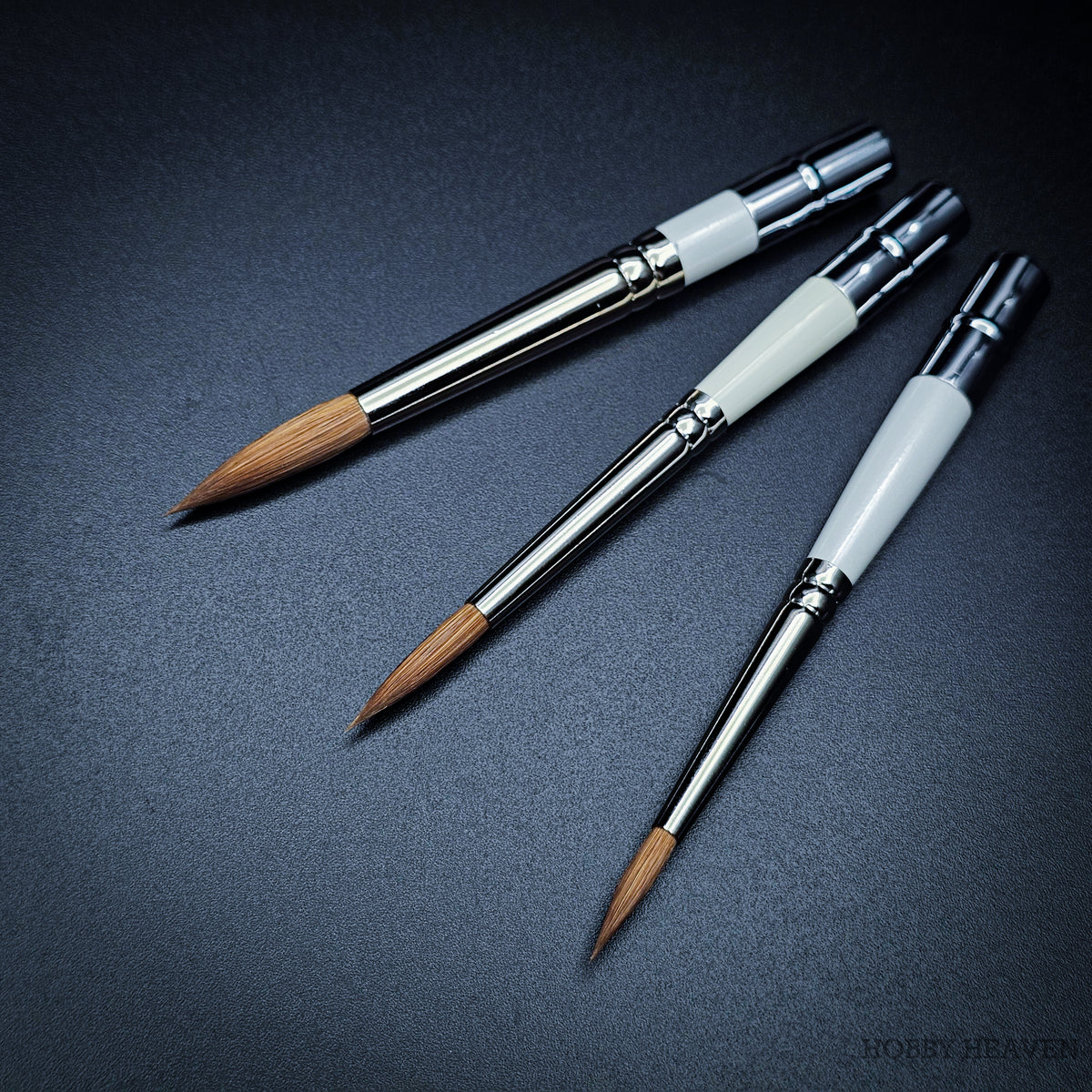 Three Pocket Kolinsky brushes from above showing white ferrule section and Kolinsky sable heads with handles extended