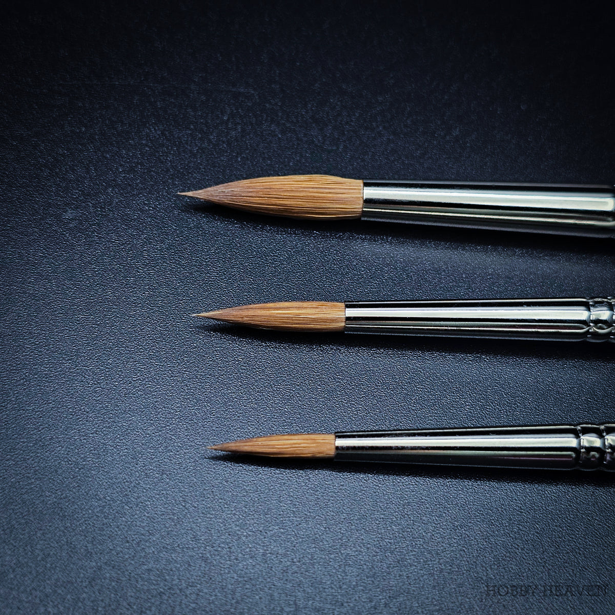 Close-up of three Kolinsky sable brush heads in sizes 4, 6 and 8 showing naturally tapered pointed round tips