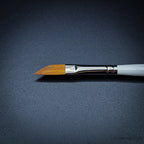 Close-up of R12 dagger brush head showing the angled sable-nylon blade with chrome ferrule