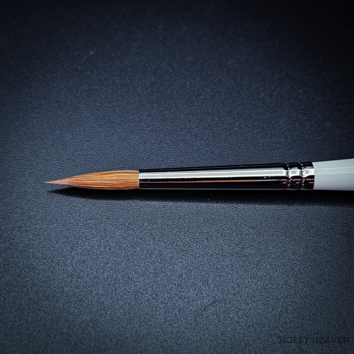 Close-up of R1 Kolinsky sable pointed round brush head showing the naturally tapered fine point