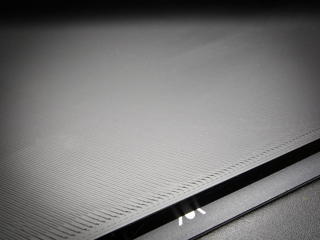 Close-up of the corner of the 300mm square smooth PLA base showing FDM layer lines along the sharp 90-degree edge.
