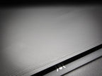Close-up of the corner of the 300mm square smooth PLA base showing FDM layer lines along the sharp 90-degree edge.