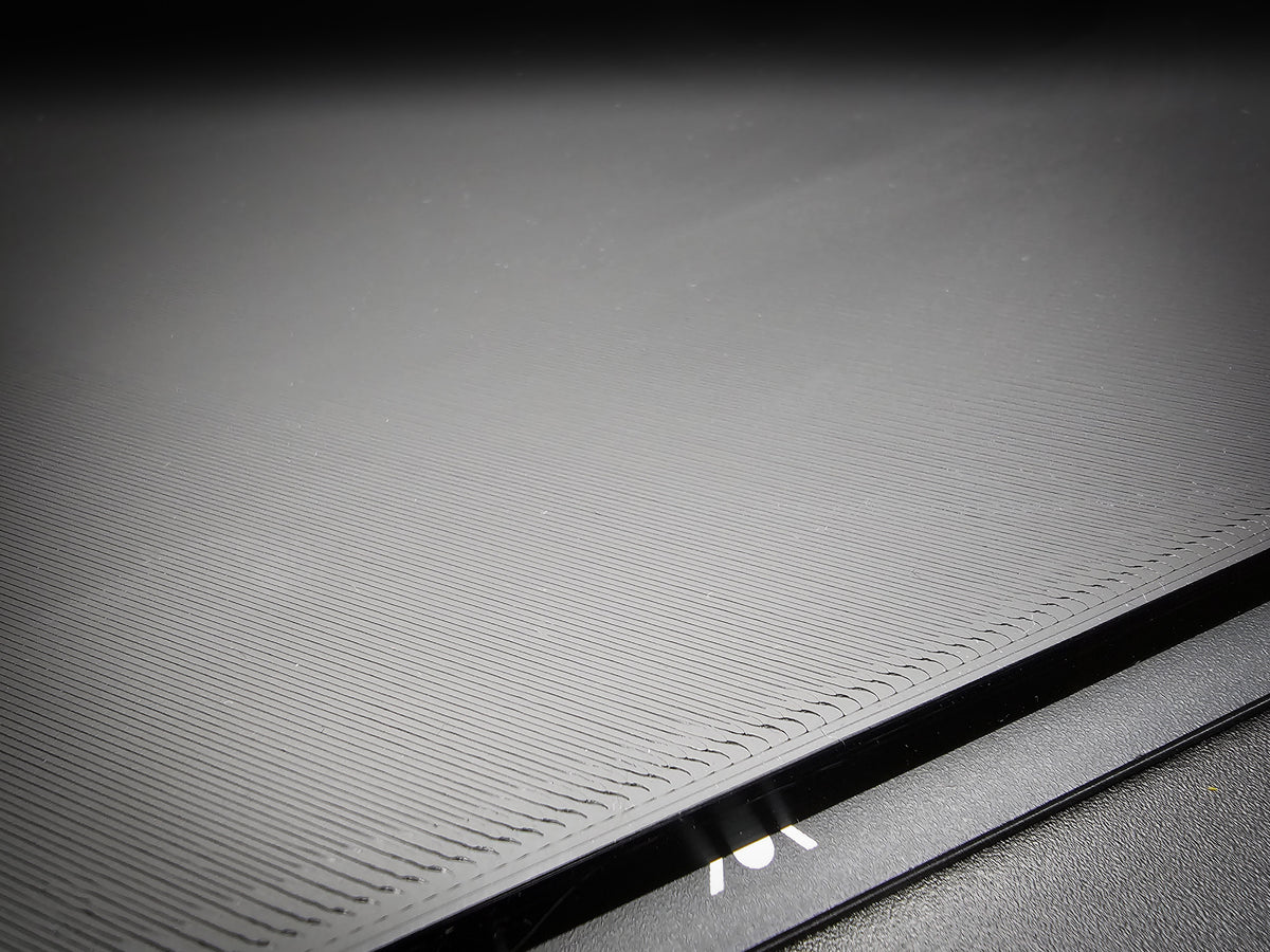 Close-up of the corner of the 300mm square smooth PLA base showing FDM layer lines along the sharp 90-degree edge.