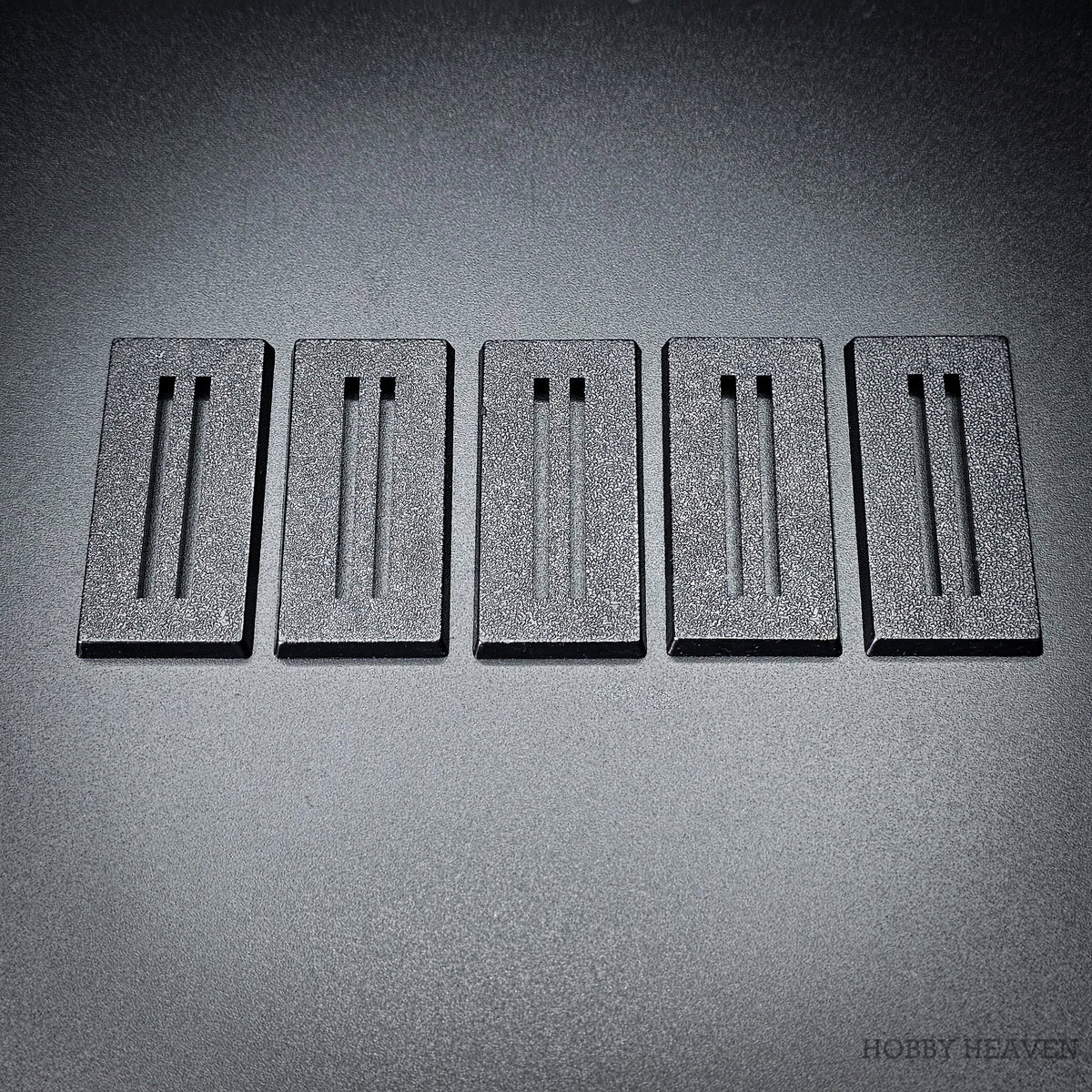 Five black 50x25mm rectangle slotted bases in a row
