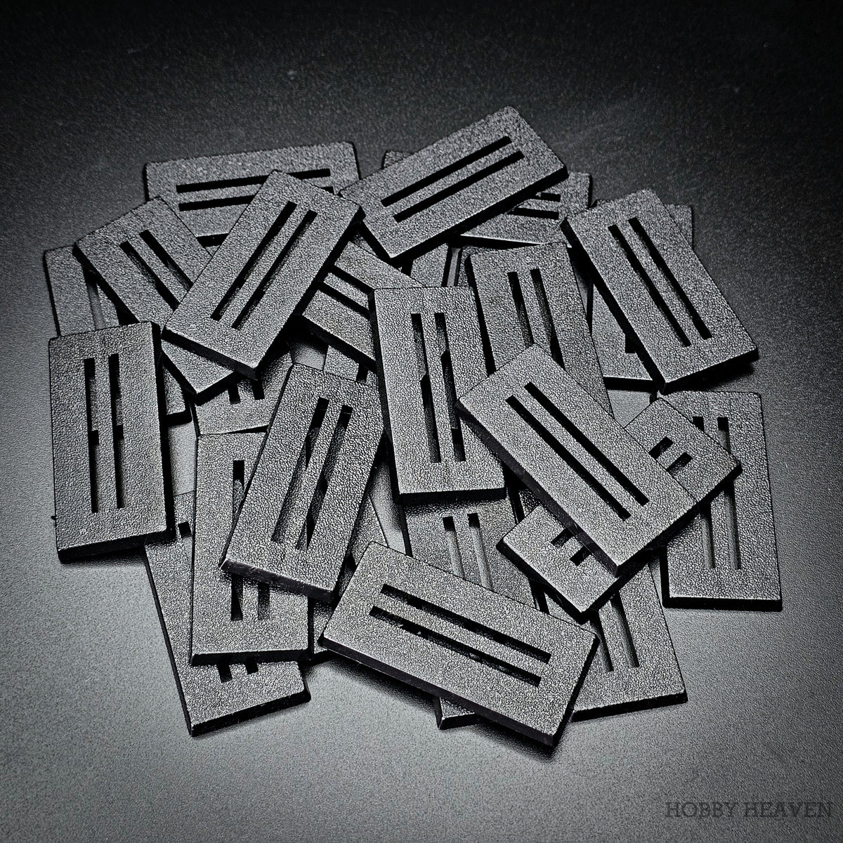 Loose pile of black 50x25mm rectangle slotted bases