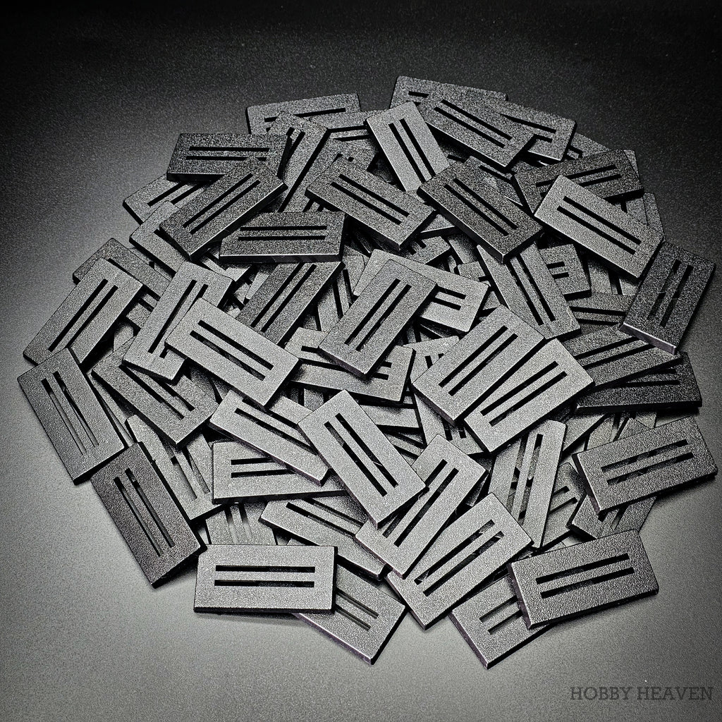 Pile of black 50x25mm rectangle slotted plastic bases, injection-moulded ABS