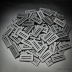 Pile of black 50x25mm rectangle slotted plastic bases, injection-moulded ABS