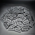 Large heap of black 50x25mm rectangle slotted bases on a grey background