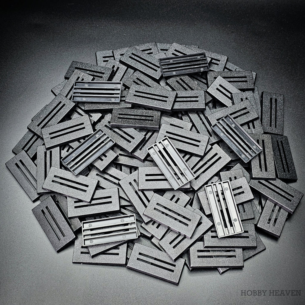 Heap of 50x25mm slotted bases, some turned over to show the open underside