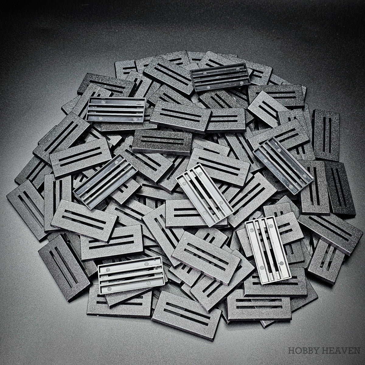 Heap of 50x25mm slotted bases, some turned over to show the open underside