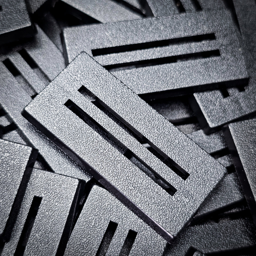 Detail of a 50x25mm slotted base: textured top, clean slot edges and bevelled rim