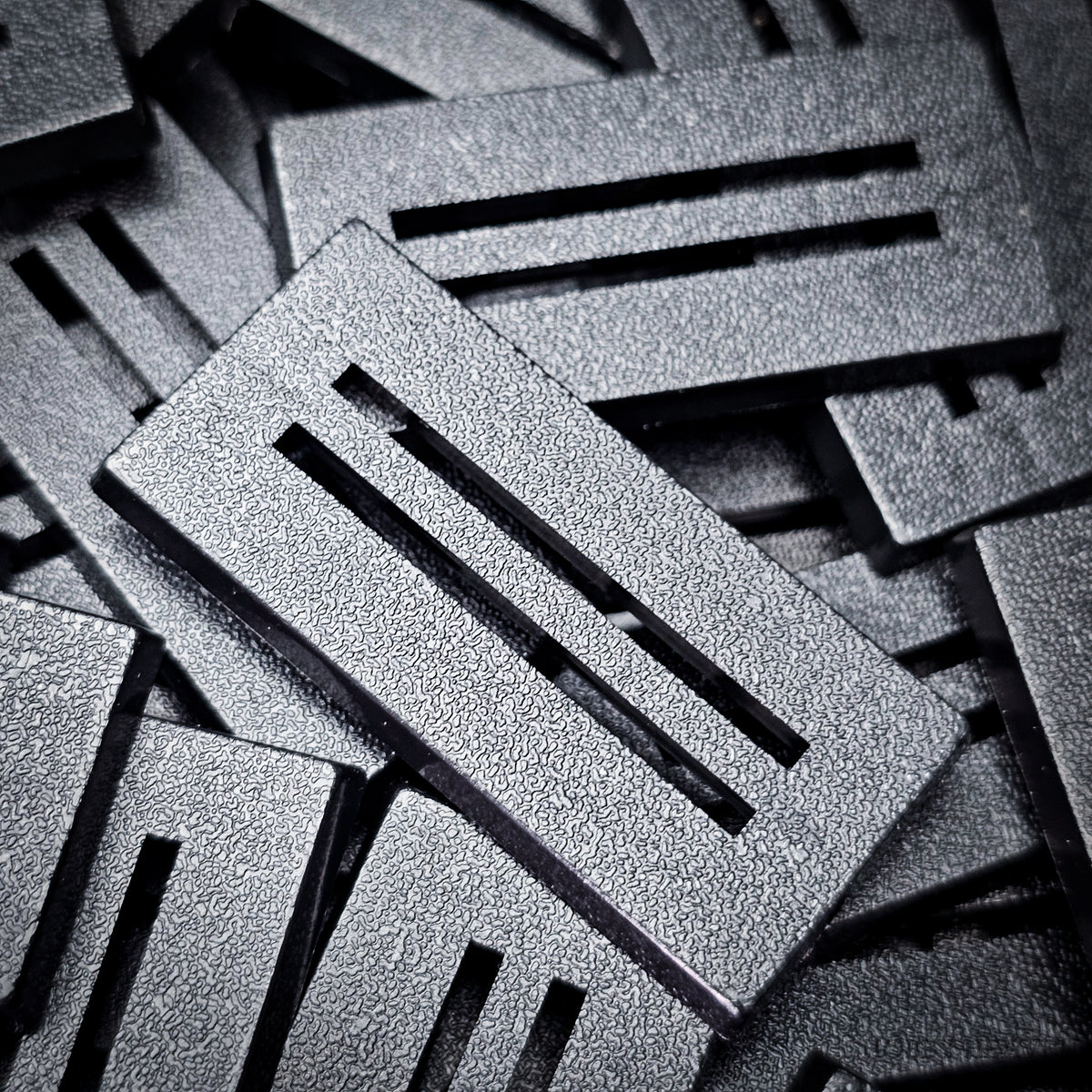 Detail of a 50x25mm slotted base: textured top, clean slot edges and bevelled rim