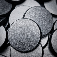 Detailed shot of a single 28mm round base, focusing on the quality of the material and the finish
