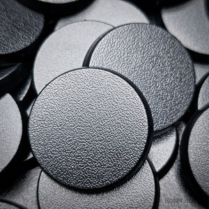 Detailed shot of a single 28mm round base, focusing on the quality of the material and the finish