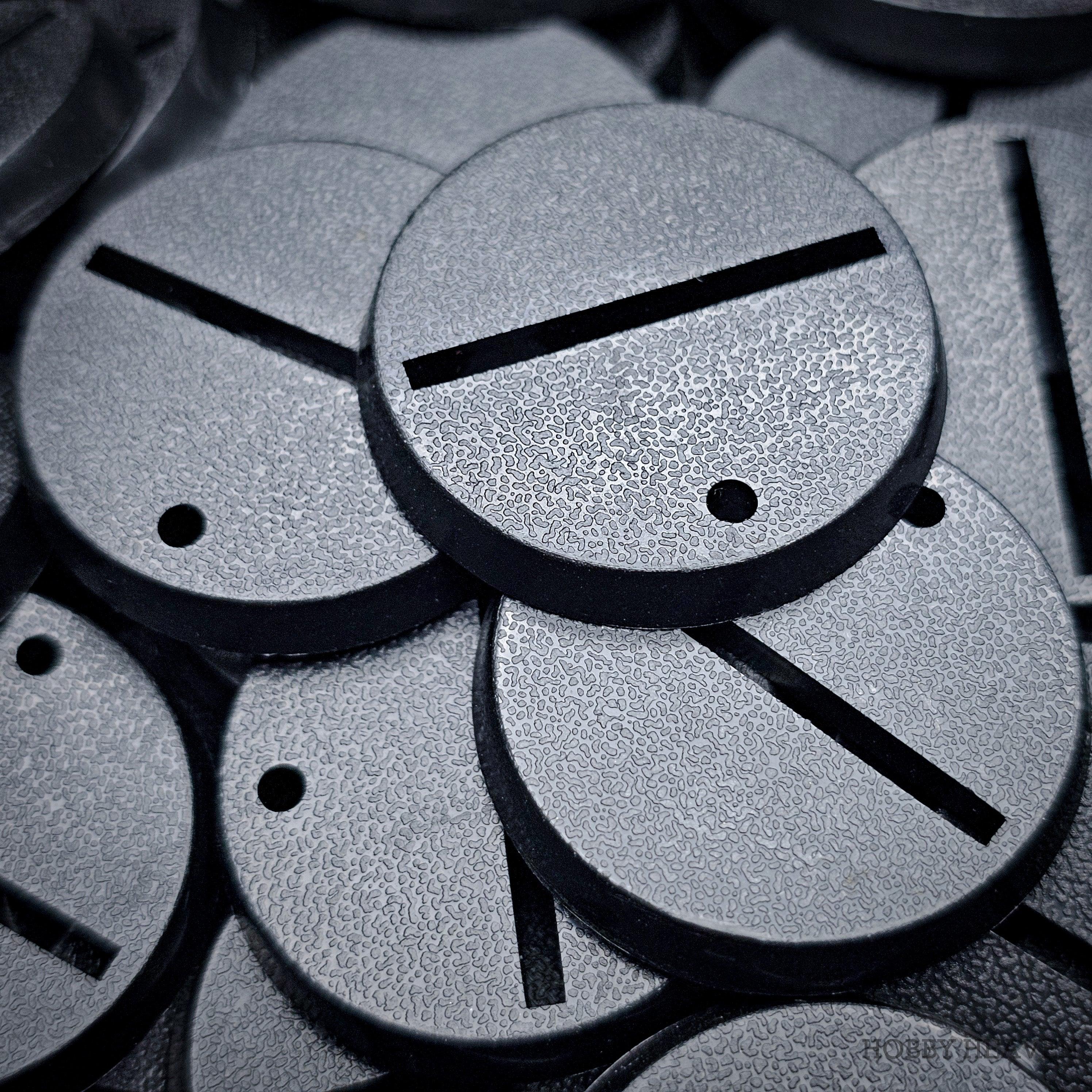 Detailed close-up view of 32mm slotted bases amidst a heap of assorted bases.