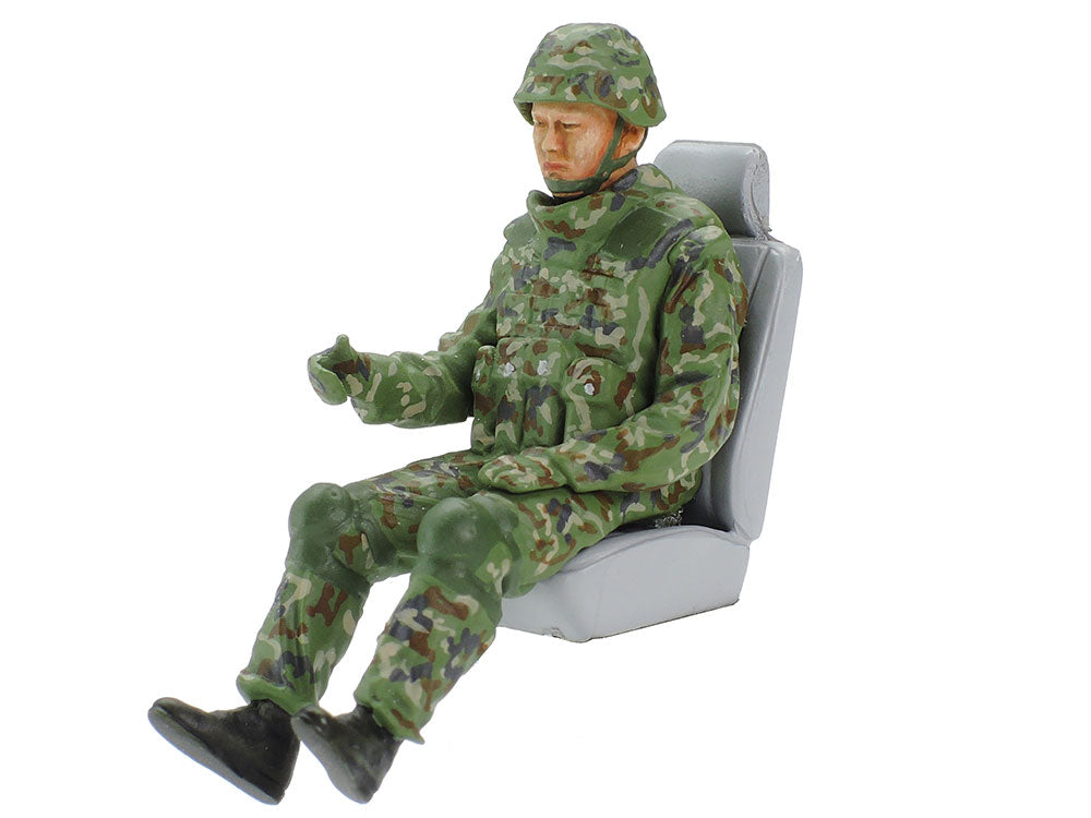 The driver figure in camouflage and body armour, seated