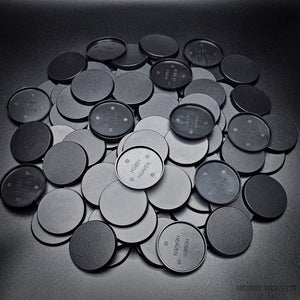 Collection of 50mm round bases lying together on a black background