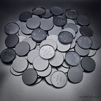 Collection of 50mm round bases lying together on a black background
