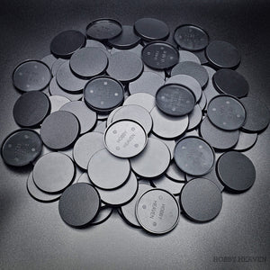 Collection of 50mm round bases lying together on a black background