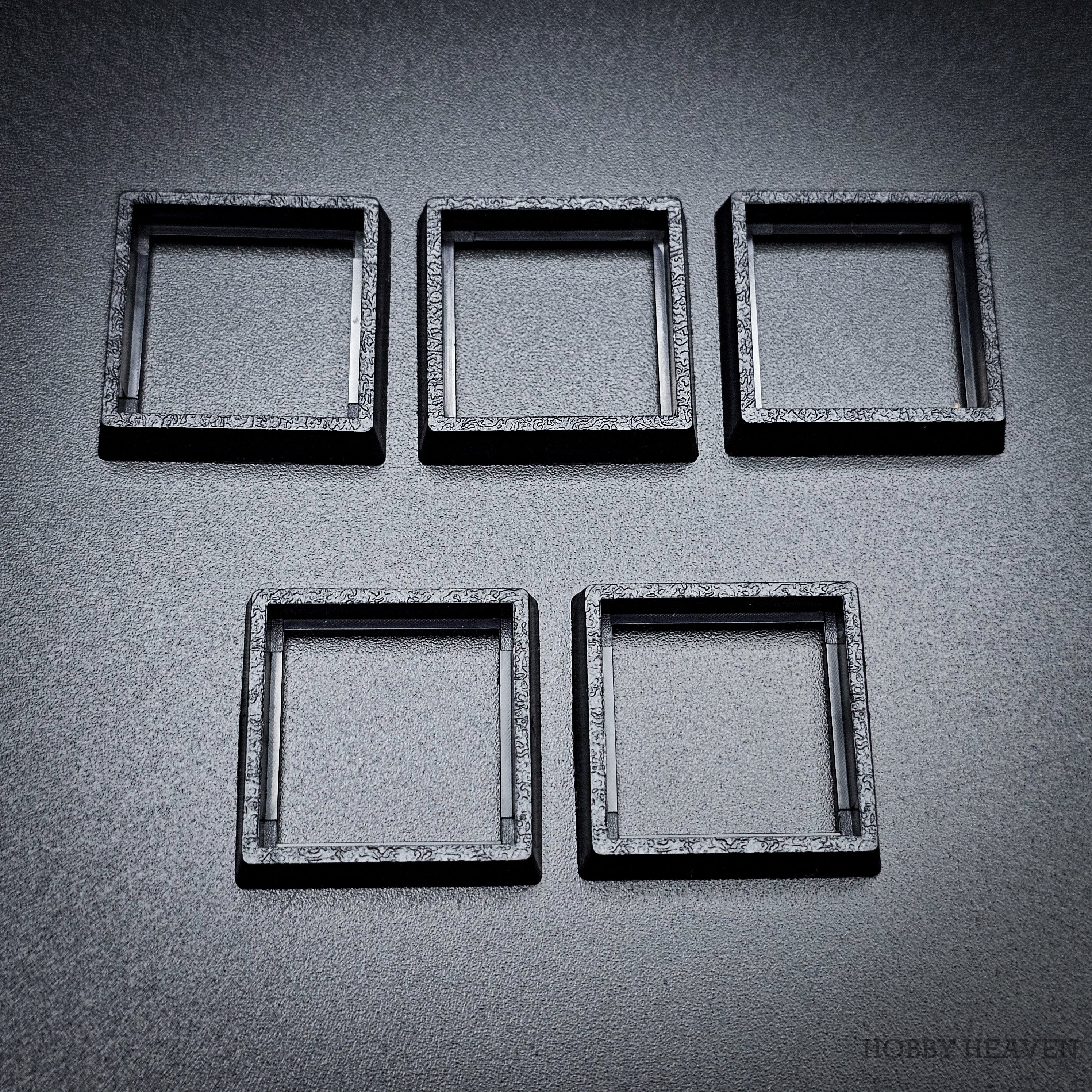 Five 20-25mm square base converters arranged showing size and texture detail
