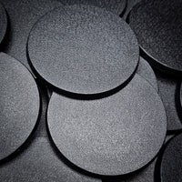 Detailed close-up of several 60mm round bases on a black backdrop, showcasing their finish"
