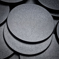 60mm round bases in close-up on black background, showing texture and quality
